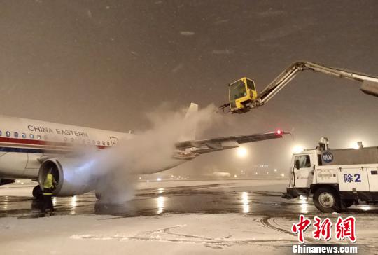 雨雪天，机务人员给飞机除冰雪。