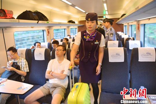 图为D7554次列车员协助旅客放置大件行李。　陈文 摄