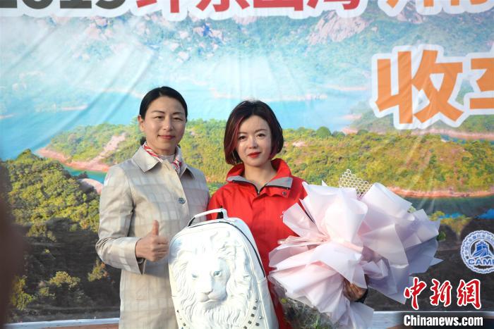 漳州市副市长吴卫红(左)为车手李海颁发特别纪念品。　龚雯 摄