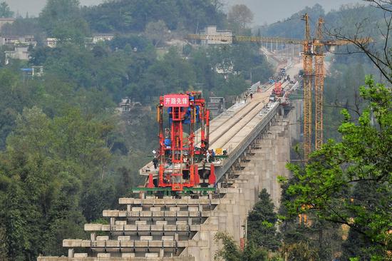▲2018年3月，川藏铁路成雅段全长1687米的猫庙河特大桥正在进行架梁施工 图据ICphoto