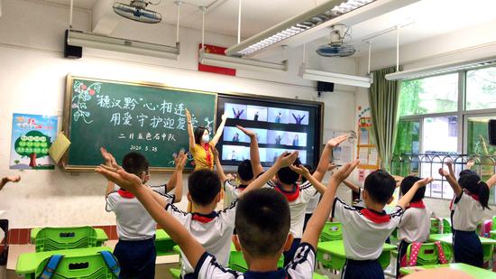 广州市海珠区宝玉直实验小学与武汉市育才第二小学、贵州省瓮安一小三校在云端举行“手拉手”复学升旗礼。