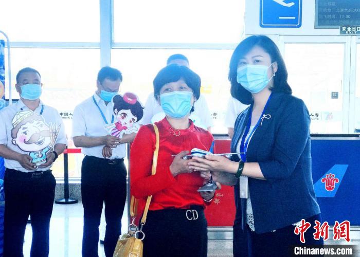 南航新疆分公司党委书记王曼(右一)为购买了此次航班首张机票的乘客杨素梅赠送纪念品。　张思维 摄