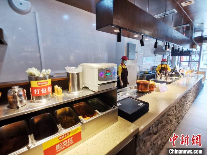 6月5日，广西桂林市区东西巷内一家五星级的明桂米粉店取餐配菜区。　欧惠兰 摄