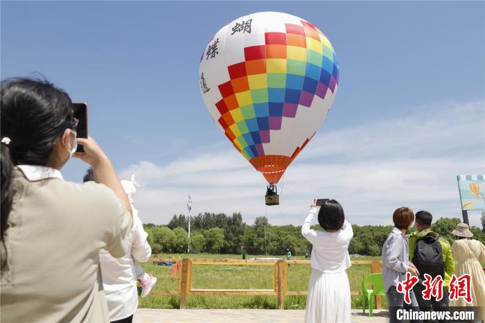 游客用手机拍摄热气球景观 吕品 摄