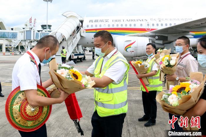云南德宏芒市机场工作人员献花迎接西藏航空机组人员。　聂渝航 摄