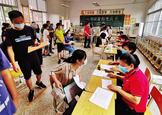 ▶今年7月，家长带着孩子办理初中新生入学报名手续。